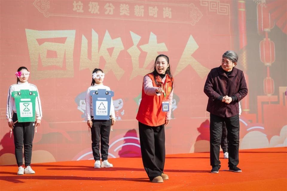 台上宣传垃圾分类，台下居民踊跃参与，小小烟头换绿植供不应求