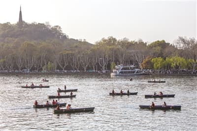 年轻人开发游湖"隐藏玩法" 坐自划船去西湖"躺平" 景区建议：量力而行