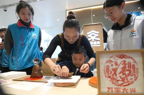 北京大兴机场迎非遗中国年，传承人携志愿者为旅客送福