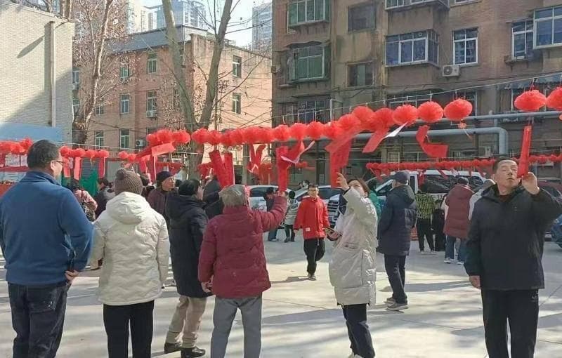 猜灯谜品元宵做游戏 居民其乐融融闹元宵